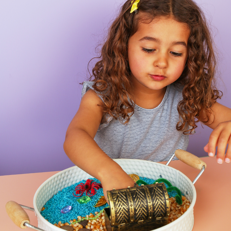 Young girl playing with a sensory play-based learning activity at home