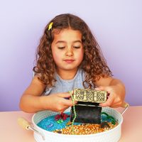Child playing with a priate sensory play tray, the perfect play-based learning activities at home
