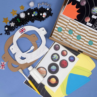 Educational space-themed craft kit with planets, stars, and astronaut helmet on a blue background.