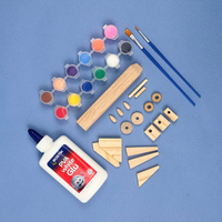 Art supplies including glue, paint, and wooden shapes on a blue background for the Space Shuttle project for kids age 7-9 from My Mini Maker