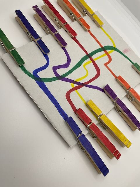 Child matching coloured pegs to lines on the colour matching board