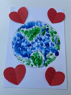 Finished Earth picture made with torn blue and green paper and a red heart