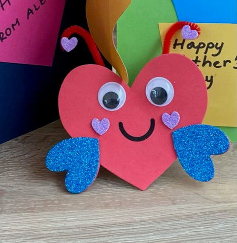 Love bug craft made from pipe cleaners, pom-poms and googly eyes