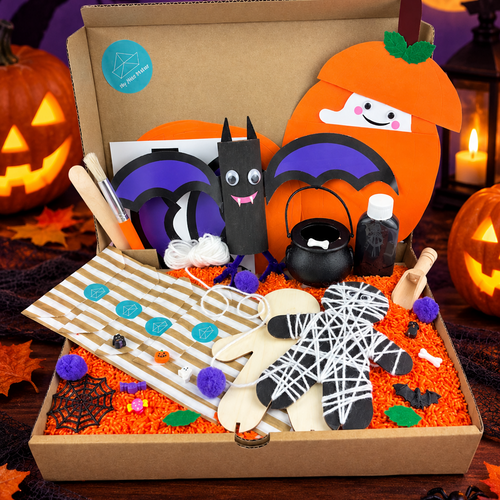 Halloween Activity Kit box filled with an orange rice sensory base, a toilet roll bat with purple wings, a ghost peeping from an orange pumpkin, a wooden mummy wrapped in white string, a cauldron, pom-poms and a wooden scoop